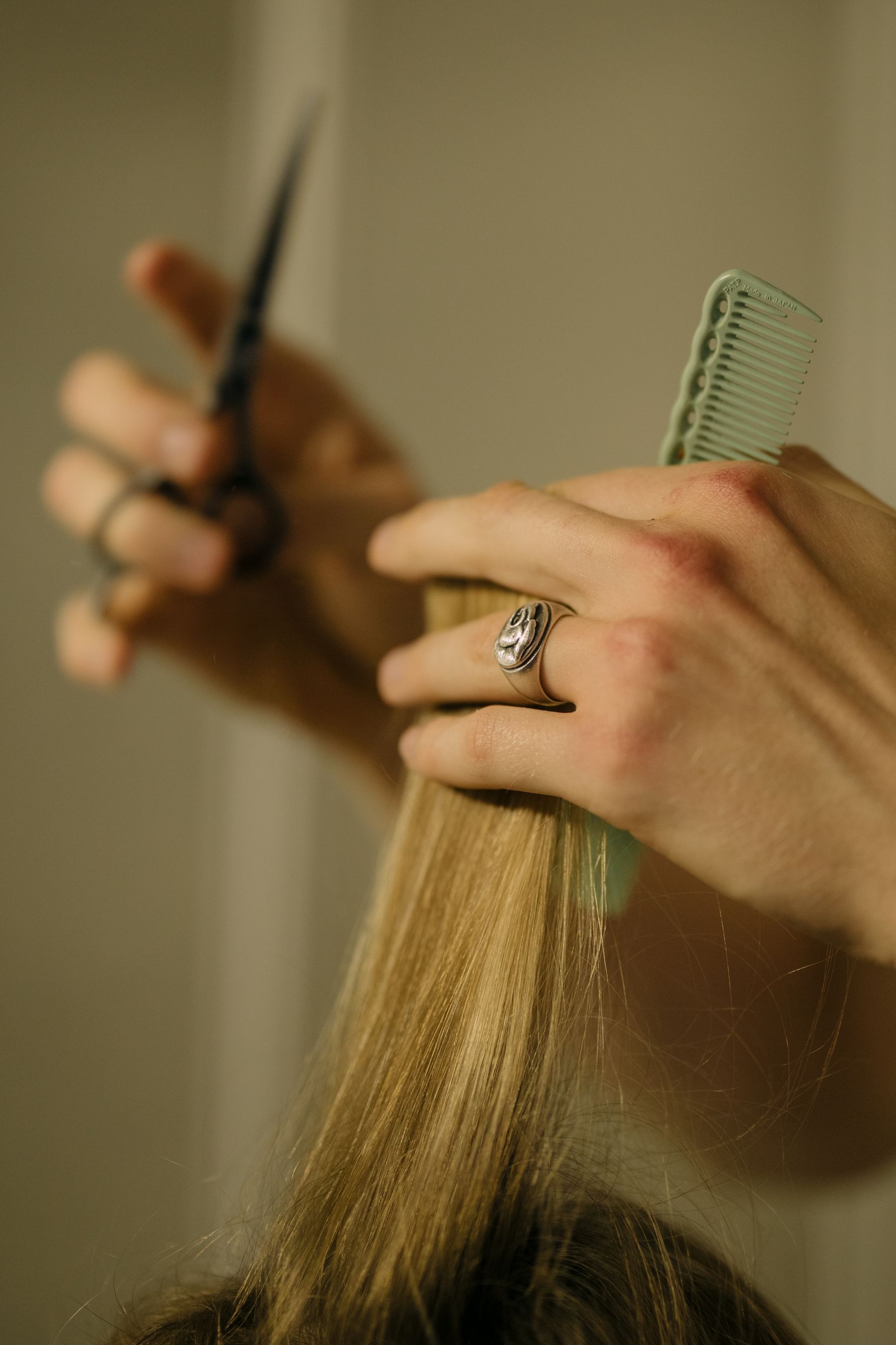 Hairdresser trimming hair with scissors and a comb