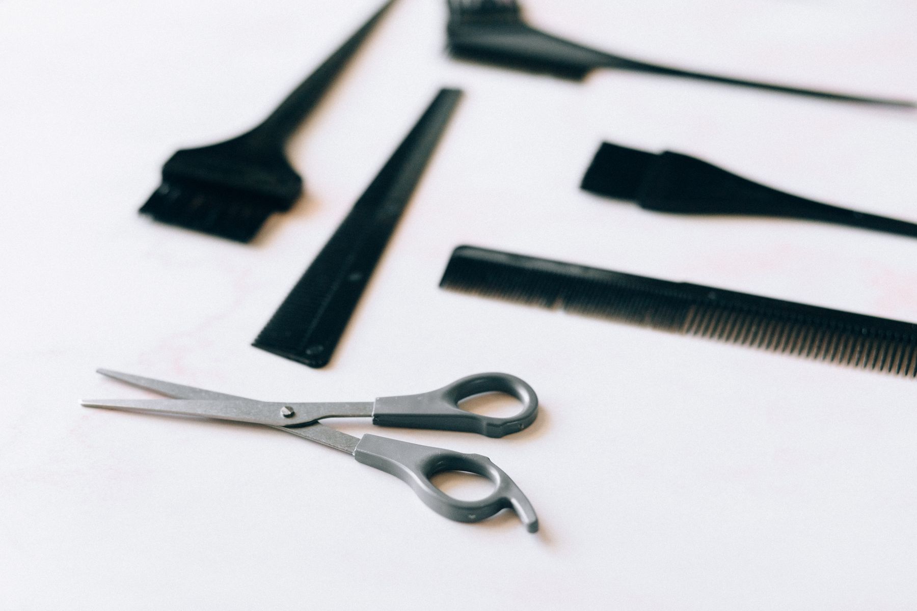 Hairdressing scissors and combs on a white surface
